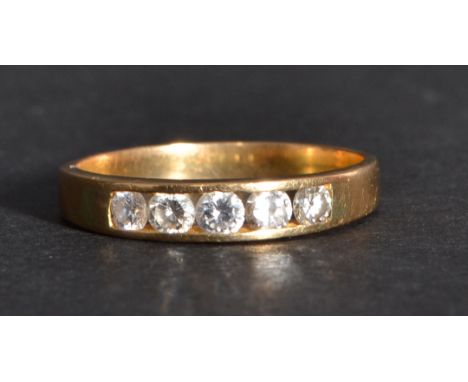 A 14k gold diamond band ring having four inset diamonds. Size R weighs 2.9 grams.