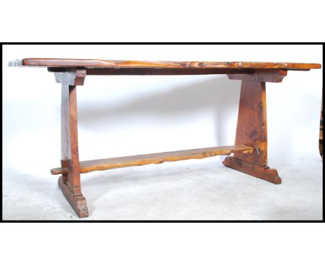 An early to mid 20th century large trunk wood refectory dining table. Raised on shaped supports united by stretchers having a