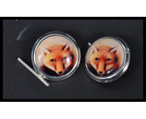 A pair of sterling silver and enamel cuff-links having pictorial images of foxes , hunting interest. Weighs 10 grams.