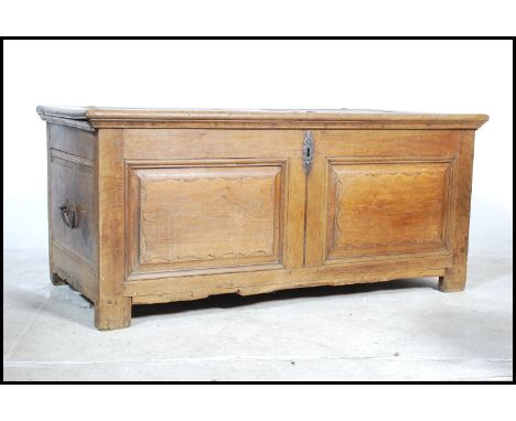 A 19th century French oak / chestnut coffer chest having a large hinged top over fielded panel body with forged iron hinged p