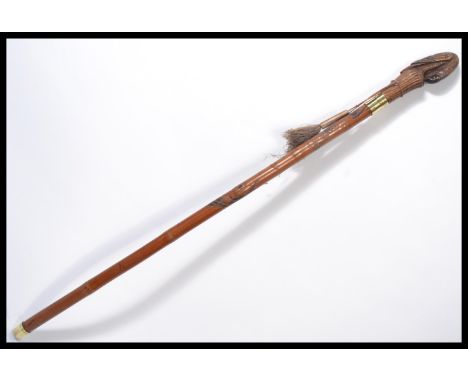 A vintage 20th century walking stick cane having a tapering wooden shaft carved with monkeys and birds with brass collar and 