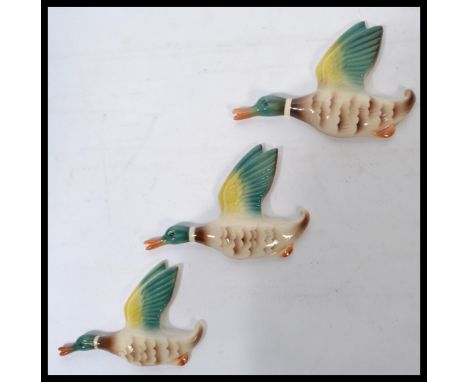 A set of three graduating vintage mid 20th century ceramic wall hanging Mallard Ducks, impressed marks to verso England. Meas