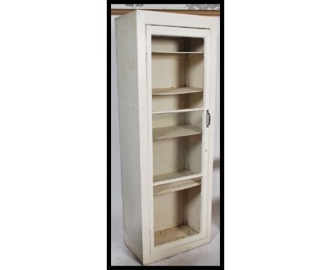 An early 20th century painted pine shop keepers cabinet. The upright sentry box style cabinet with full length door having gl