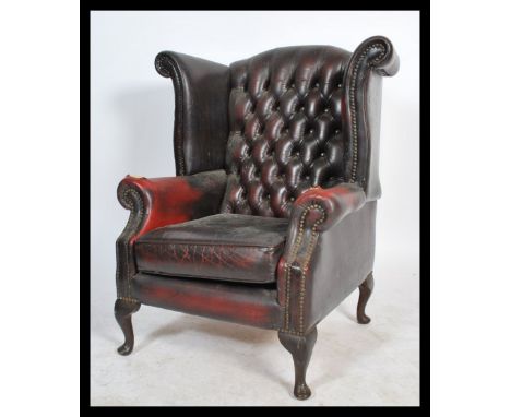 A 20th century Antique style oxblood leather chesterfield armchair being raised on cabriole legs upholstered in studded oxblo