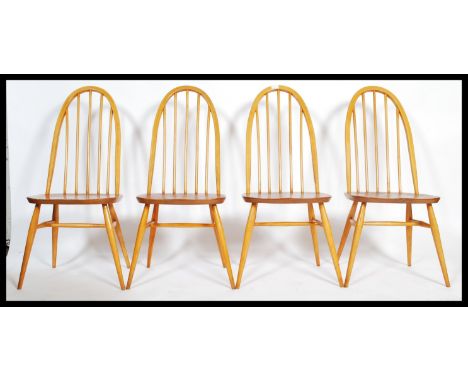 A set of four mid 20th century Ercol Windsor Quaker hoop-back dining chairs in light elm and beech. Measures 97cm x 41cm x 41