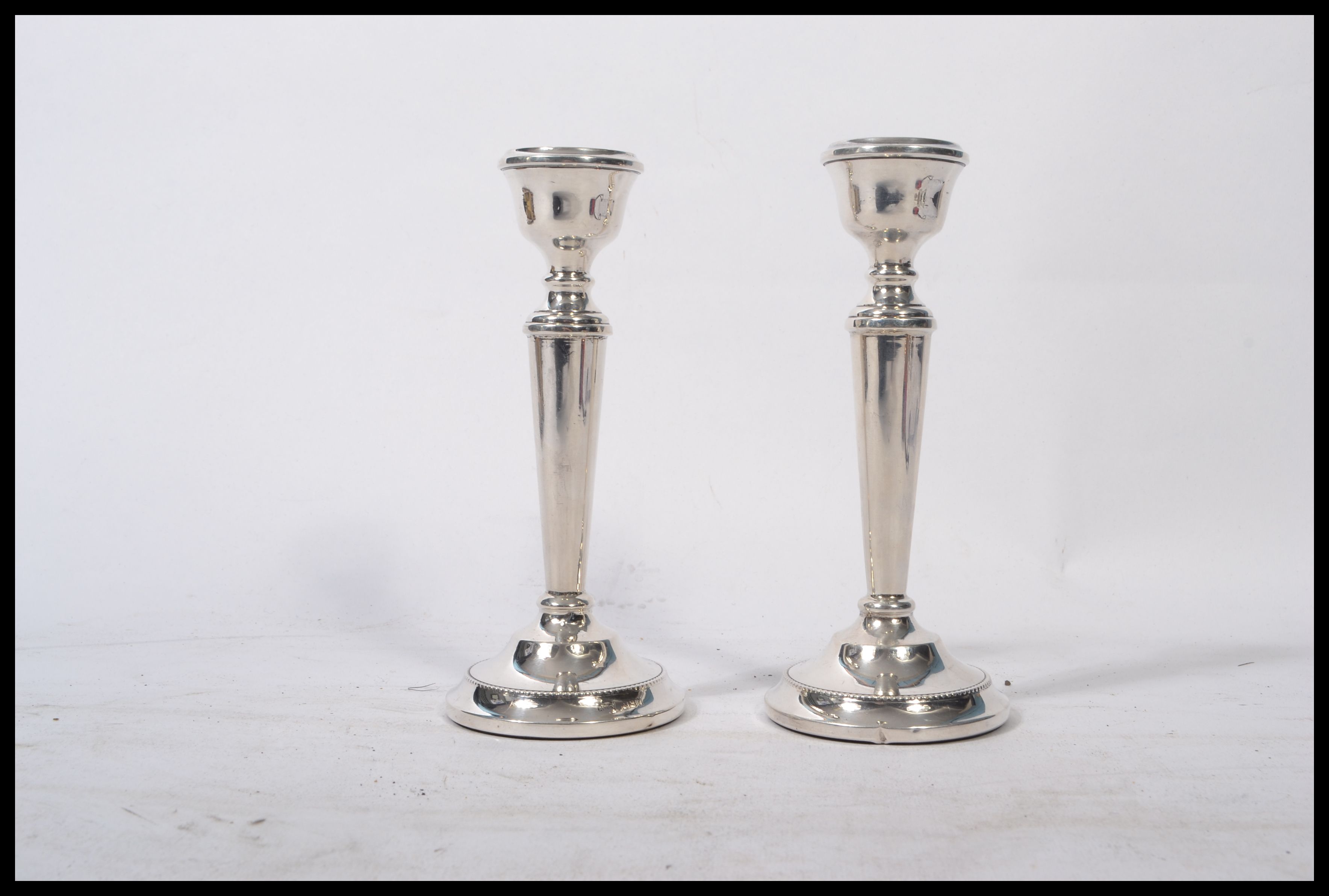 A pair of silver hallmarked filled stub candlesticks, Birmingham assay ...