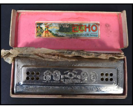 A Hohner Echo harmonica retaining original box and packaging instructions to the inner.