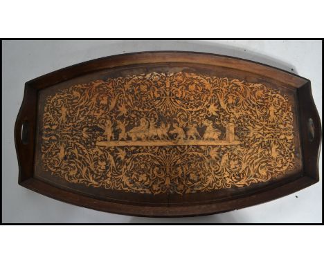 An early 20th century Sorrento ware burl wood tray having marquetry inlaid decoration depicting a procession of fairy riding 