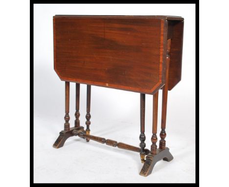 An Edwardian mahogany inlaid Sutherland table having an inlaid top being raised on ring turned legs with drop leaves supporte
