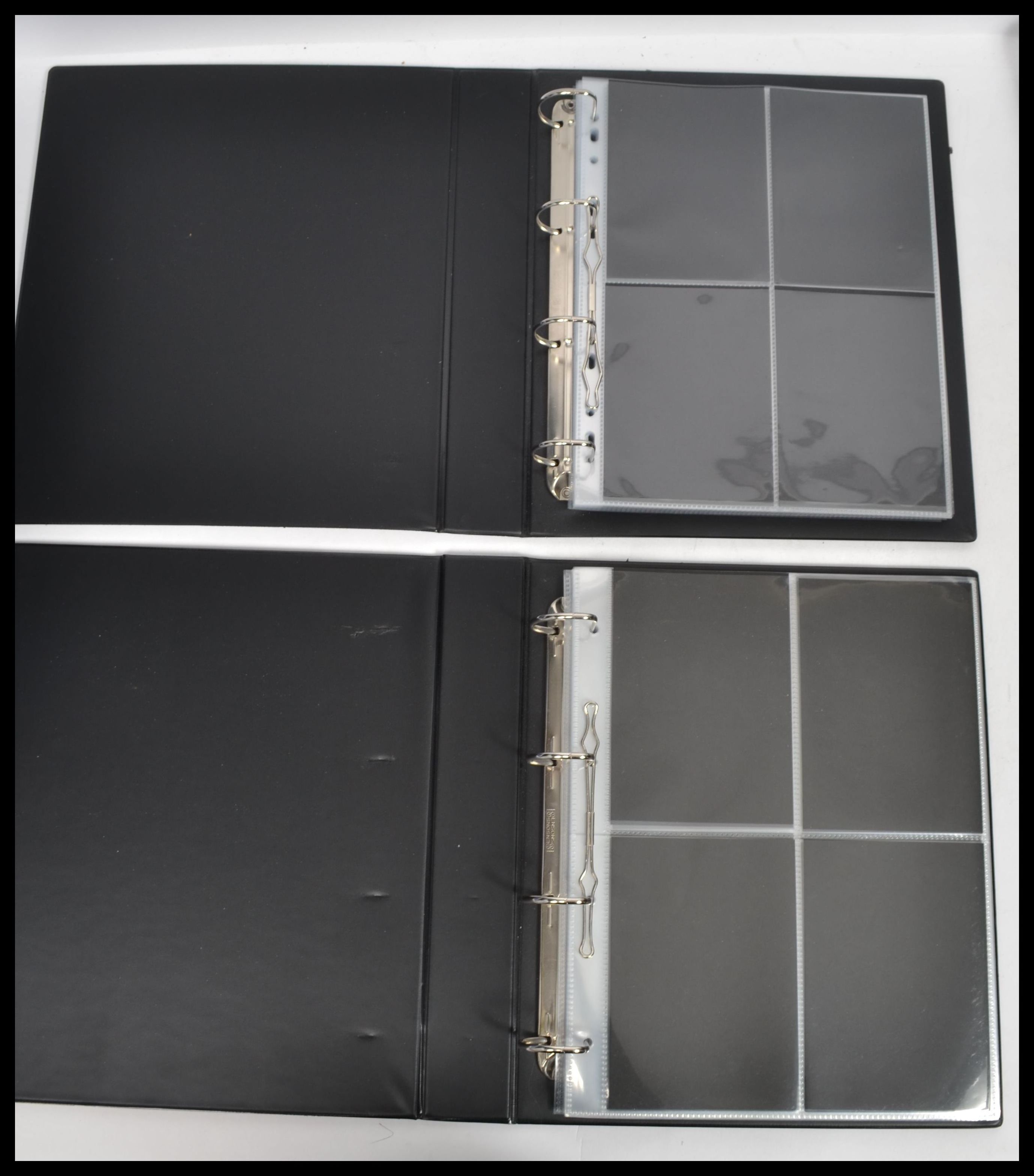 A group of postcard albums and sleeves in binders. Black vinyl albums.