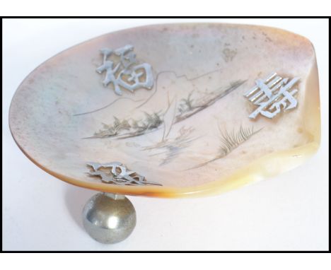 A 19th century Chinese silver and mother of pearl salt / trinket dish raised on three ball feet with silver Chinese lucky cha