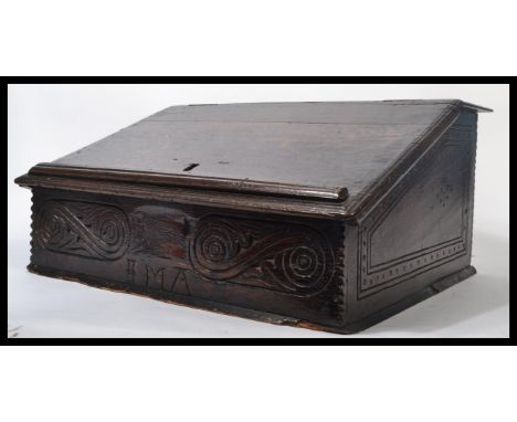 A 17th century Jacobean oak and elm clerks desk / bible box, hinged sloping lift up top with scratch-work side panels, geomet