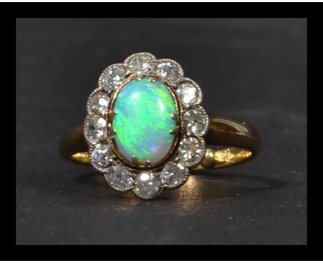 An 18ct gold opal and diamond ring having a fantastic central opal with a halo of old cut diamonds of approx 60pts. Weighs 3.