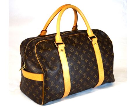 A Louis Vuitton monogram carryall travel bag 
The canvas exterior with extended top zip detail and tan leather side straps an