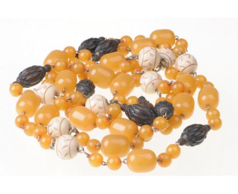 An amber style, ivory and ebony bead necklace
The graduated amber style beads, interspaced by carved ebony lozenges and carve