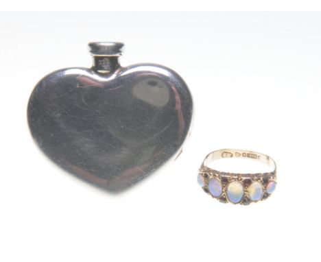 Tiffany & Co: A silver heart shaped scent bottle
Of plain form, length 4cm, together with an opal and garnet five stone ring,