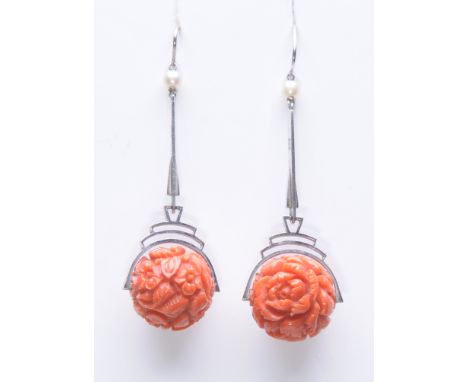An Art Deco pair of coral and seed pearl ear pendants
The foliate carved coral spheres, surmounted by a stepped setting to a 
