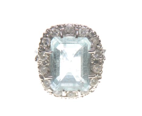 An aquamarine and diamond cluster ring
The central step-cut aquamarine, to an illusion set brilliant-cut diamond surround, mo