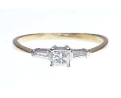 A diamond three stone ring
Centering a princess-cut diamond, to tapered baguette cut shoulders, to 18ct gold, total diamond w