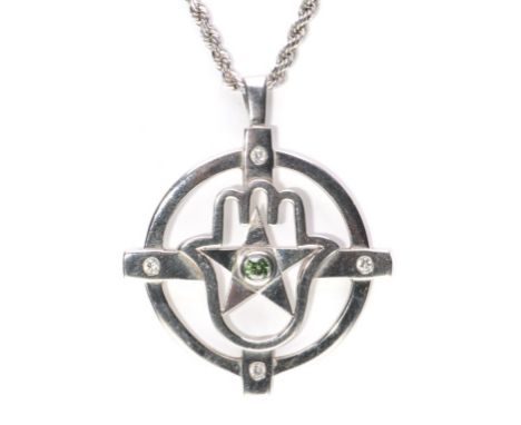 A diamond mounted Hand of Hamsa pendant
Centered with a brilliant cut green diamond flanked by four round cut white diamonds,
