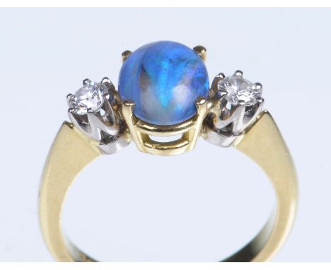 An 18ct gold blue opal and diamond set three stone ring
The central oval cabochon opal of approx 10x7mm, predominantly blue c