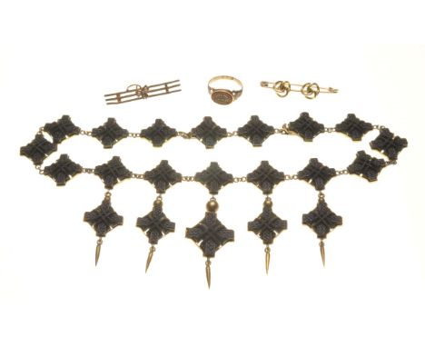 A Victorian bog oak necklace, circa 1870
Composed of a uniform row of lozenge shaped panels, each decorated with carved Celti