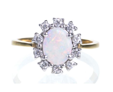 An opal and diamond cluster ring
The oval shaped opal, set within a surround of ten round brilliant-cut diamonds, to a yellow