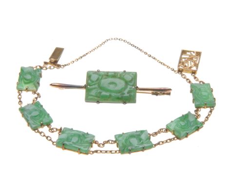 A jade bracelet and brooch suite
The bracelet made up of rectangular carved jade panels, interspaced by parallel cable link c