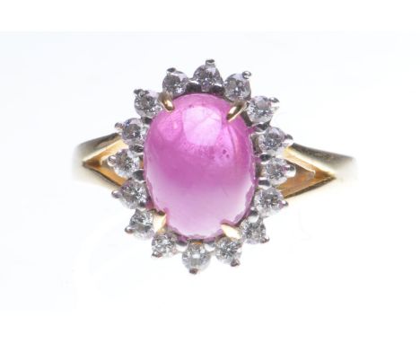 A ruby and diamond cluster ring
The oval cabochon-cut ruby, to a round brilliant-cut diamond surround, to an 18ct gold mount,
