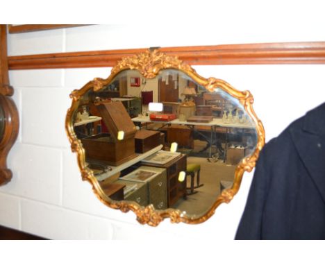 A gilt framed shaped wall mirror 