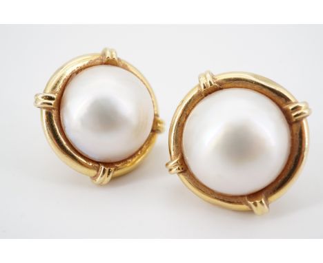 A pair of modern mabe pearl and high carat yellow metal statement earrings, each pearl being sunken set within a reeded and w