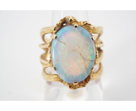 A contemporary high carat yellow metal and opal statement ring, of organic design, having a central opal cabochon of approxim