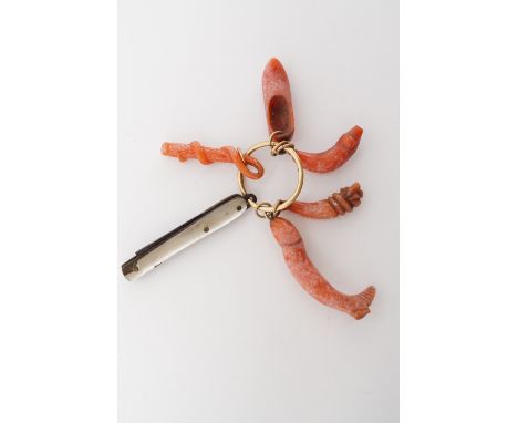 19th Century carved coral charms on a yellow-metal ring, one modelled as a slipper, another as a fish, suspended alongside a 