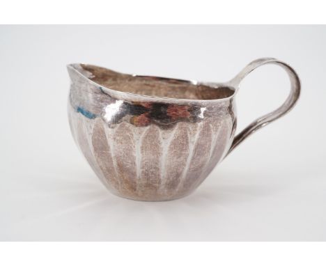 A Keswick School of Industrial Arts signed silver jug, of globular form, with whiplash handle, and beaten decoration, signed 