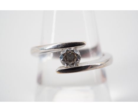 A contemporary diamond solitaire ring, of approximately .25ct, the brilliant-cut diamond held in a captive setting between th