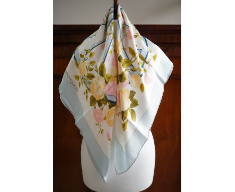 A vintage Hermes 'Romantique' pattern silk scarf designed by Maurice Tranchant, with powder blue border, and pastel blossoms,