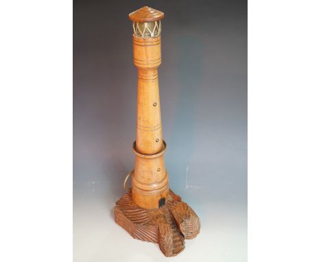 A vintage novelty table lamp modelled as a lighthouse, of turned and carved wood, 72 cm high