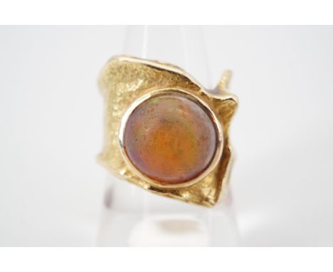 A contemporary high carat yellow metal and opal statement ring, of softly textured malleable design incorporating the craftsm