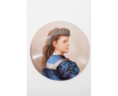 A late 19th / early 20th Century porcelain plaque depicting the profile portrait of a young lady, her brown hair worn in long