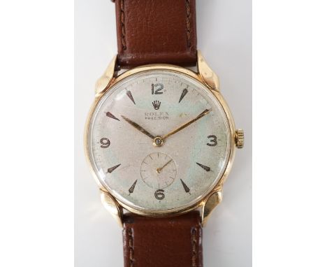 A 1950s Rolex 9ct gold wrist watch, having a precision manual-wind movement and frosted silver face with gilt dagger markers,