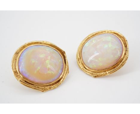 A pair of contemporary high carat yellow metal and opal ear clips, each having a central circular cabochon of approximately 2