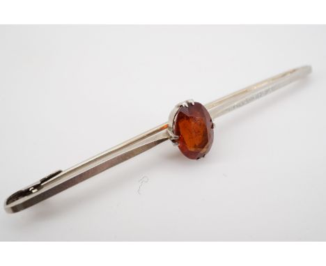 A vintage high carat white metal and citrine bar brooch, comprising an oval cut and faceted citrine of approximately 2.4ct, c