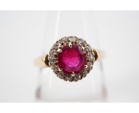 A vintage diamond and ruby flower head cluster dress ring, having a central round-cut claw-set ruby of approximately 1 ct, th