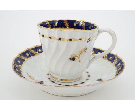 A Worcester Flight, Barr and Barr period tea cup and saucer, spirally fluted, decorated with a cobalt blue and gilt foliate b