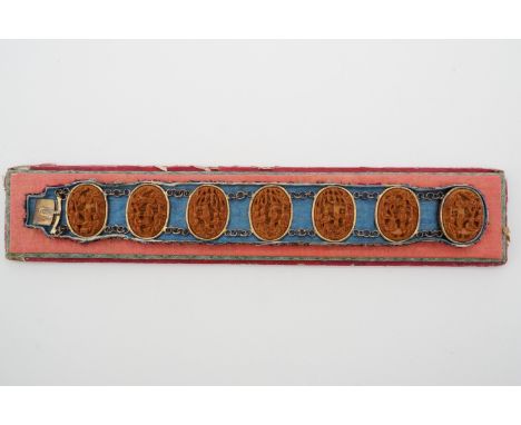 A late 19th Century Chinese bracelet for the Western market, comprising seven carved wooden plaques depicting figural scenes,