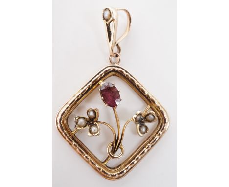 A Belle Epoque antique almandine garnet and split seed pearl openwork pendant, having a whiplash flower claw-set with an oval
