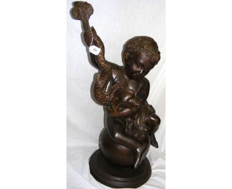 A bronze figure of a cherub seated on a globe and holding a stylized dolphin - 79cm high overall