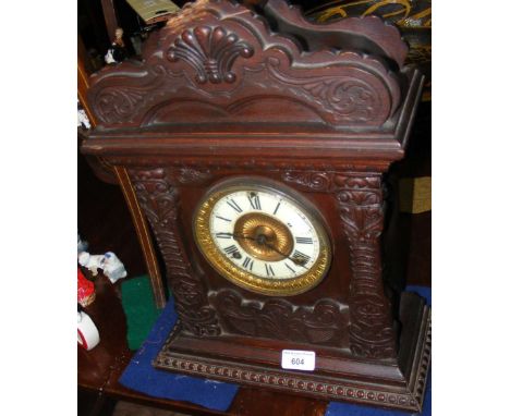 An antique wooden cased mantel clock