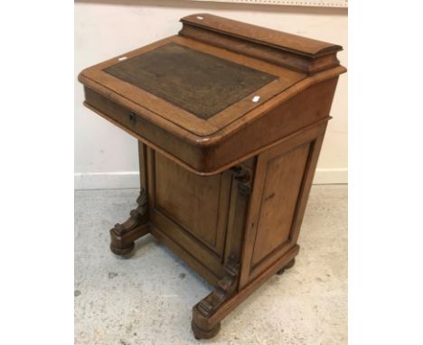 A Victorian oak Davenport, the top with stationery compartment over a writing surface, rising to reveal a birds eye maple lin
