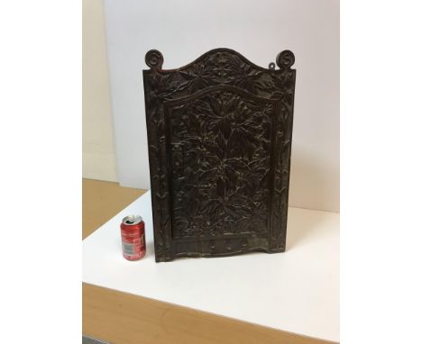 An early 20th Century Arts and Crafts carved oak hanging corner cupboard, the door and frame with all over foliate decoration